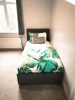 a small bedroom with a bed with a green bedspread at Spacious 3 Bedroom Home, Sleeps 7, Long-Stay & Contractor Friendly, Family & Professional Ready, Clark Property Estates in Southend-on-Sea