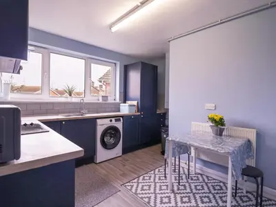 a kitchen with a table and a washing machine at The Upper Circle in Clacton-on-Sea