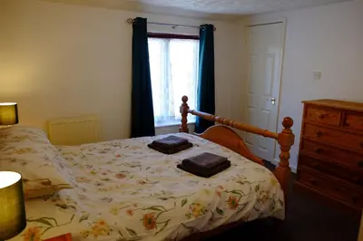a bedroom with a bed with two towels on it at Cosy Cottage to Relax or Explore in Mistley