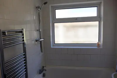 a bathroom with a window and a bath tub at Cosy Cottage to Relax or Explore in Mistley