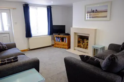a living room with two couches and a fireplace at Cosy Cottage to Relax or Explore in Mistley