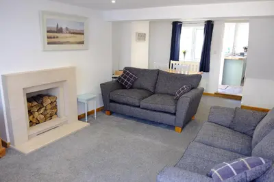 a living room with a couch and a fireplace at Cosy Cottage to Relax or Explore in Mistley