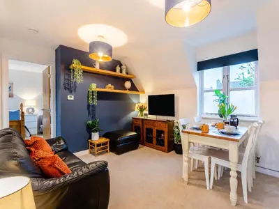 a living room with a table and a dining room at Bluebell Lodge in Longstowe