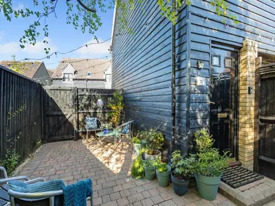 a patio with chairs and plants and a fence at Bluebell Lodge in Longstowe