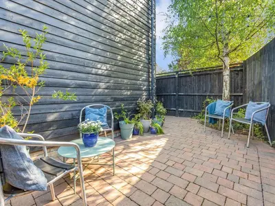 a patio with chairs and plants and a fence at Bluebell Lodge in Longstowe