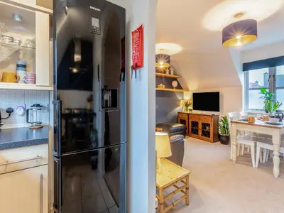 a kitchen with a refrigerator and a dining room at Bluebell Lodge in Longstowe