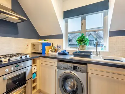 a kitchen with a washing machine and a sink at Bluebell Lodge in Longstowe