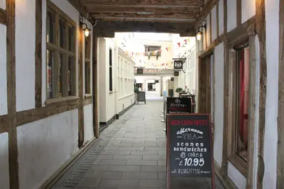 an alley with a sign on the side of a building at Brook Red Lion Hotel in Colchester