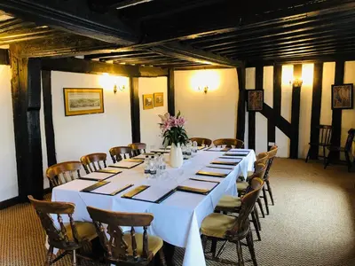 a large long table in a room with chairs at Brook Red Lion Hotel in Colchester