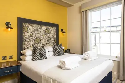 a bedroom with a large bed with towels on it at The George Hotel Colchester in Colchester