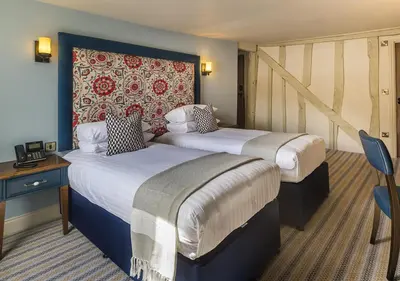 a hotel room with two beds and a wall at The George Hotel Colchester in Colchester
