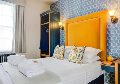 a bedroom with a bed with towels on it at The George Hotel Colchester in Colchester