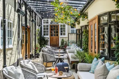 an outdoor patio with tables and chairs at The George Hotel Colchester in Colchester