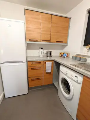 a kitchen with a refrigerator and a washing machine at 2-Bed, Sleeps 5, 2 Bath, Parking, WiFi in Colchester