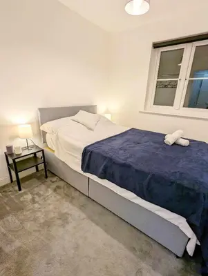 a bedroom with a large bed and a window at 2-Bed, Sleeps 5, 2 Bath, Parking, WiFi in Colchester