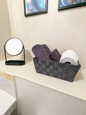 a basket of purple pillows on a counter with a mirror at 2-Bed, Sleeps 5, 2 Bath, Parking, WiFi in Colchester