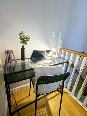 a glass desk with a laptop on a balcony at 2-Bed, Sleeps 5, 2 Bath, Parking, WiFi in Colchester