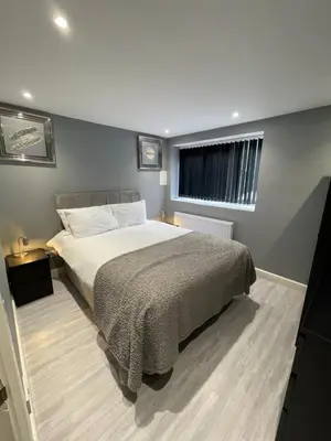 a bedroom with a large bed and a window at Brook House Annex in Ipswich