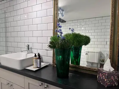 a bathroom with a sink and a vase with flowers at Characterful house in Hertford - near London in Hertford