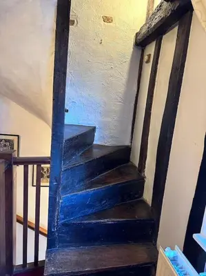 a wooden stairway with a blue painted wall at Characterful house in Hertford - near London in Hertford