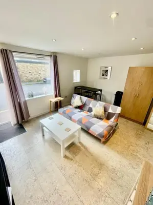 a living room with a couch and a table at Cambridge City Centre Studio, Sleeps 3 in Cambridge