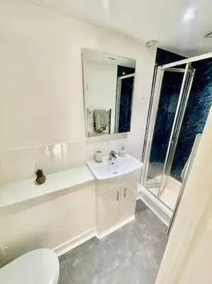 a white bathroom with a toilet and a sink at Cambridge City Centre Studio, Sleeps 3 in Cambridge