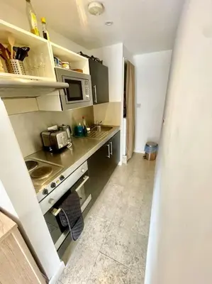 a small kitchen with a stove and a microwave at Cambridge City Centre Studio, Sleeps 3 in Cambridge