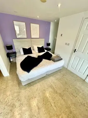 a bedroom with a large white bed with black pillows at Cambridge City Centre Studio First Floor Sleeps 3 in Cambridge