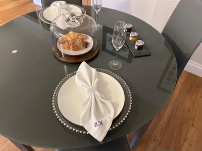 a table with a plate of food and wine glasses at Stansted Airport Stay, Parking and Luxury Suite in Bishops Stortford