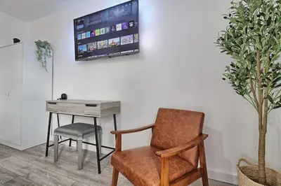 a chair and a desk with a television on a wall at High view house, 3 bed flat, Number 41A in Walton-on-the-Naze