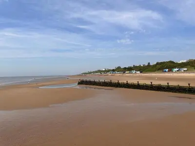 a sandy beach with a pier and the ocean at Coastal Nest - Premium flat,3 Minutes to the Beach in Walton-on-the-Naze