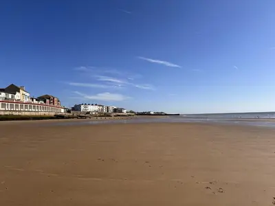 an empty beach with buildings in the background at Coastal Nest - Premium flat,3 Minutes to the Beach in Walton-on-the-Naze
