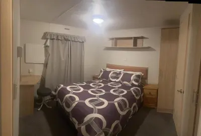 a small bedroom with a bed and a sink at Cosy holiday home stay in Great Clacton