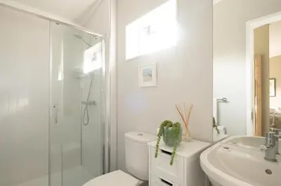 a bathroom with a shower and a toilet and a sink at Pebbles - Church Farm - Aldeburgh Coastal Cottages in Aldeburgh