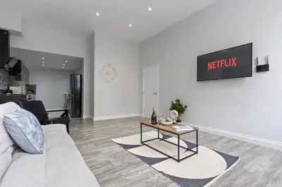 a living room with a couch and a table at Harwich Luxury Suite in Harwich