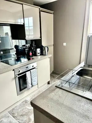 a kitchen with white cabinets and a stove top oven at Historical Police Station Building l Central Cambridge I Park View in Cambridge