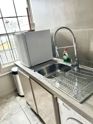 a kitchen sink with a dish drying rack next to it at Historical Police Station Building l Central Cambridge I Park View in Cambridge