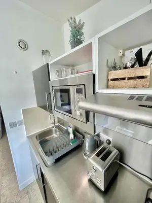a kitchen with a sink and a microwave at Studio - Sleeps 3 - Parking - Wifi in Cambridge