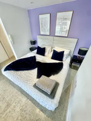 a bedroom with a large white bed with blue pillows at Studio - Sleeps 3 - Parking - Wifi in Cambridge