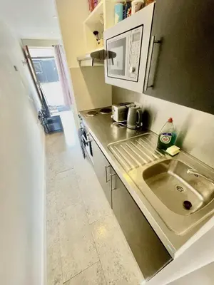 a small kitchen with a sink and a microwave at Studio - Sleeps 2 - Parking - Wifi in Cambridge