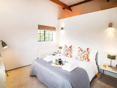 a bedroom with a bed with towels on it at The Workshop by The Suffolk Cottage Collection in Bruisyard
