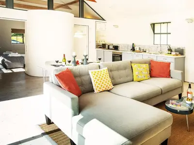 a living room with a couch with colorful pillows at The Workshop by The Suffolk Cottage Collection in Bruisyard