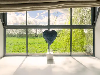 a window with a heart in a vase in a room at The Workshop by The Suffolk Cottage Collection in Bruisyard