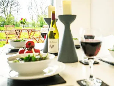 a table with a bowl of food and a bottle of wine at The Workshop by The Suffolk Cottage Collection in Bruisyard