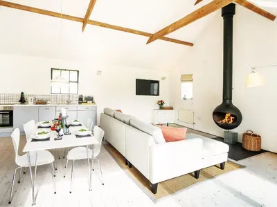 a living room with a white couch and a table at The Workshop by The Suffolk Cottage Collection in Bruisyard