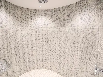 a bathroom with a tiled wall with a shower at The Workshop by The Suffolk Cottage Collection in Bruisyard