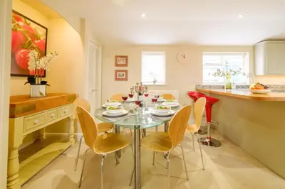 a dining room with a glass table and chairs at Tanyard House in Woodbridge