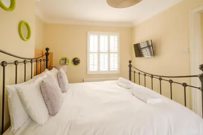 a bedroom with a bed with white sheets and pillows at Tanyard House in Woodbridge
