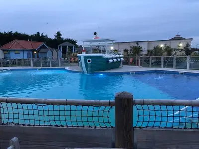 a large blue swimming pool with a boat in it at Coastal caravan retreat in Brightlingsea