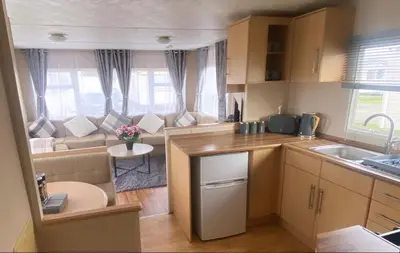 a kitchen and a living room with a couch at Coastal caravan retreat in Brightlingsea